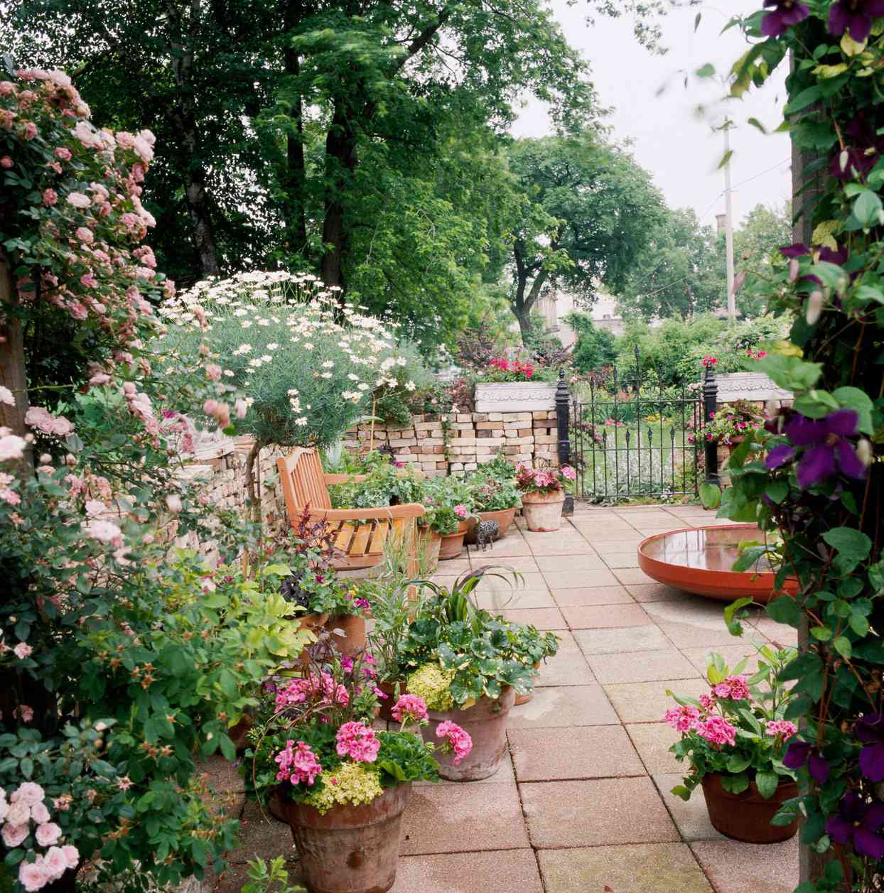 patio with fountain, bench, and flowers