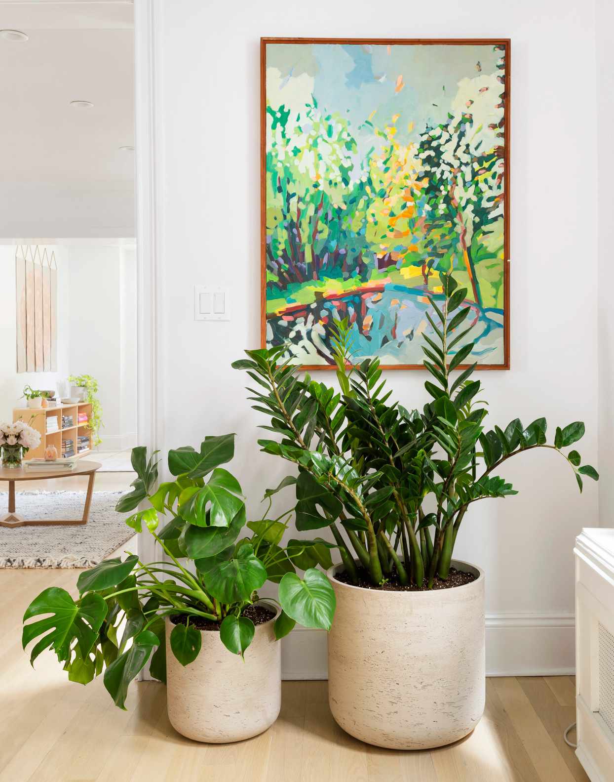 impressionist art piece hanging above tropical plants