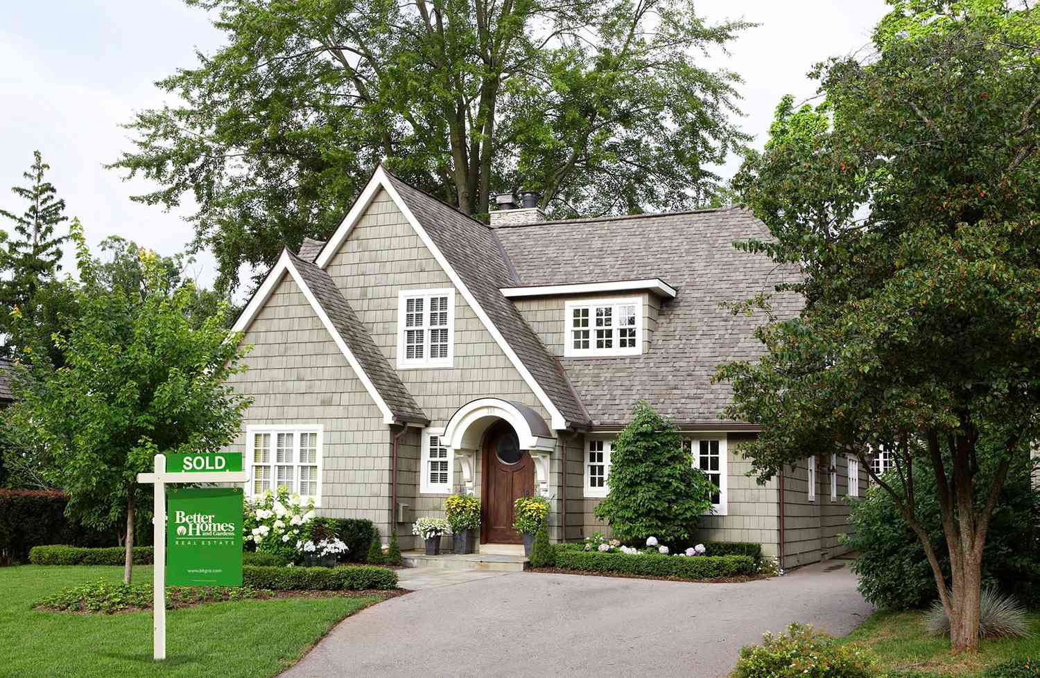 Tudor style home with sold sign in front yard BHGRE