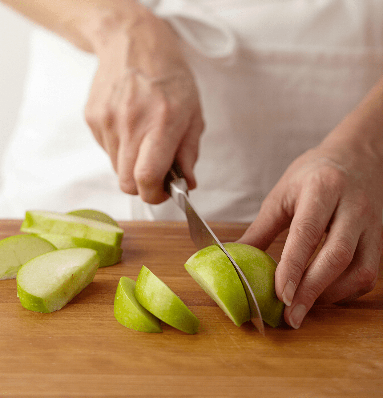 Cutting apple into wedges with chef’s knife