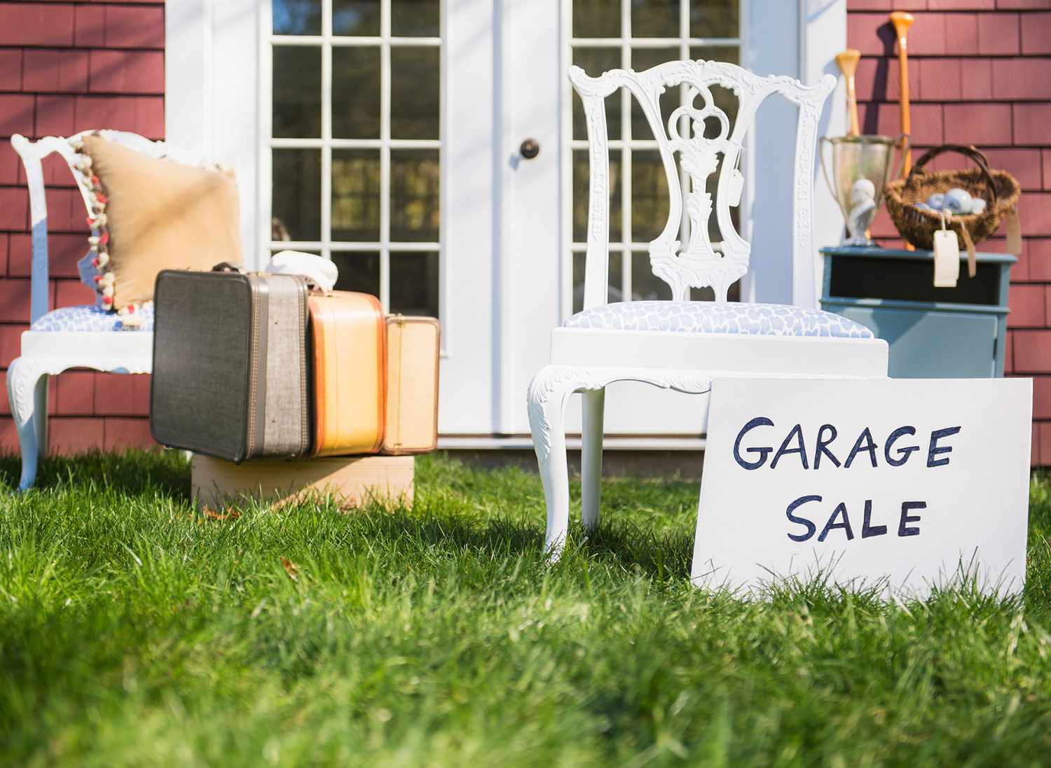 garage sale sign with items for sale on grass in front yard
