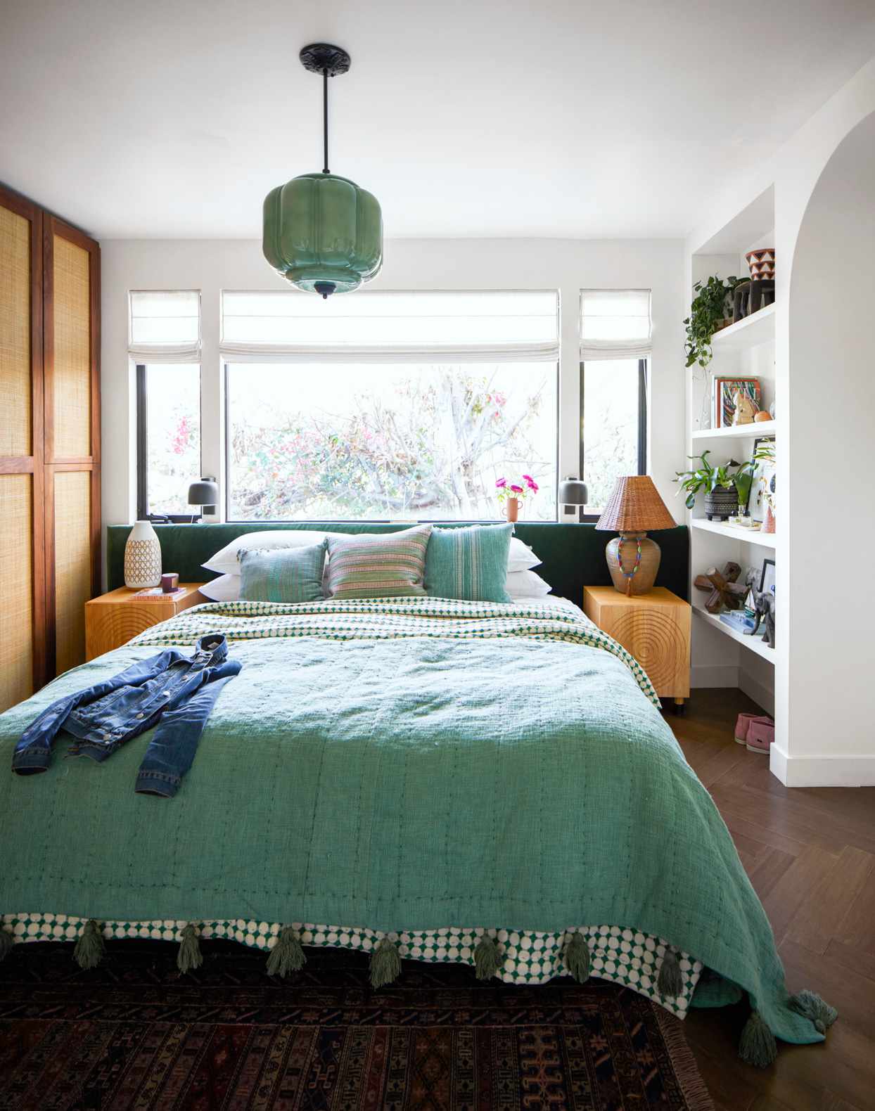 cozy bedroom with teal bed and hanging light