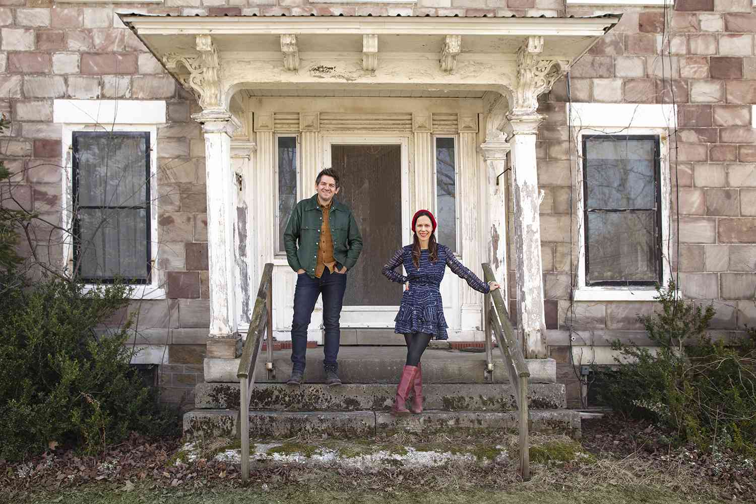 two people standing in front of historic home