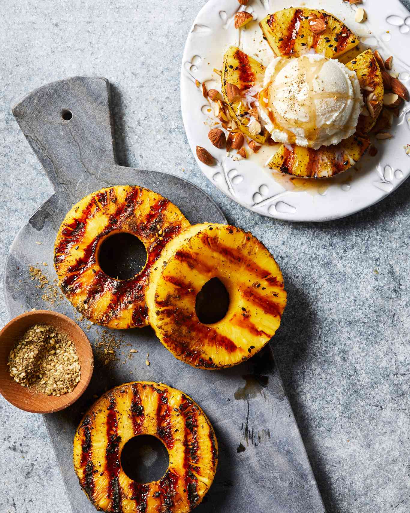 Grilled Pineapple circles with scoop of ice cream on gray background