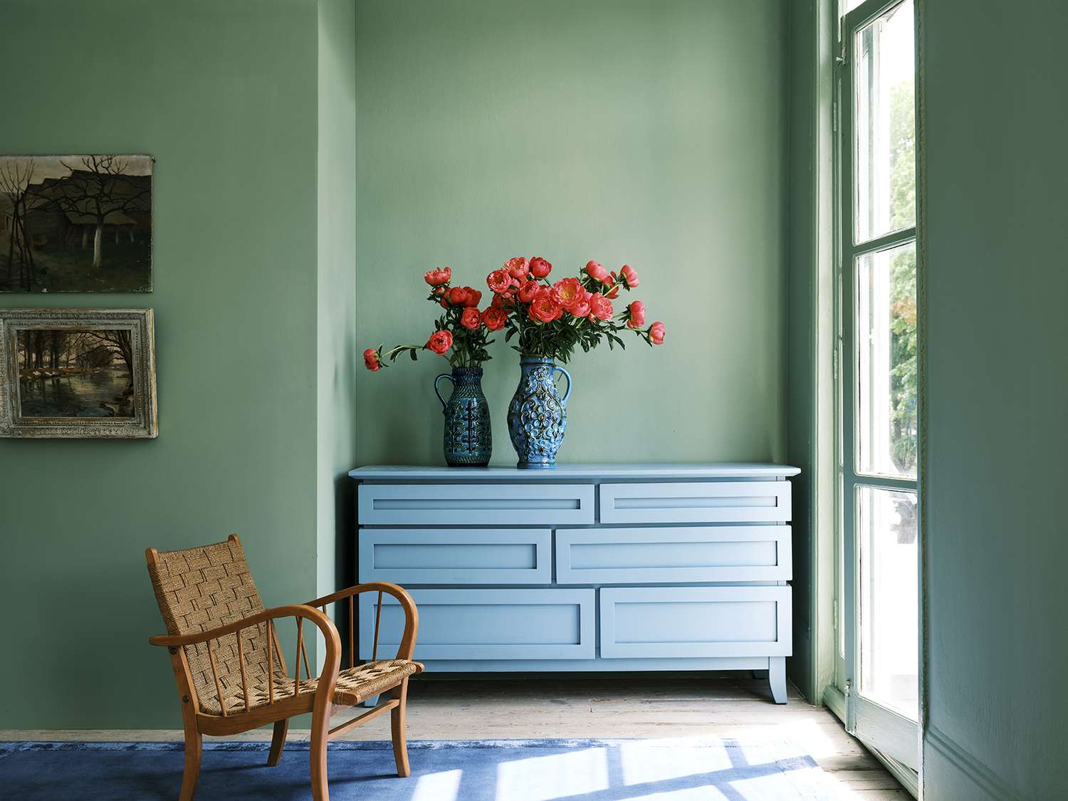 green room with blue dresser and woven chair
