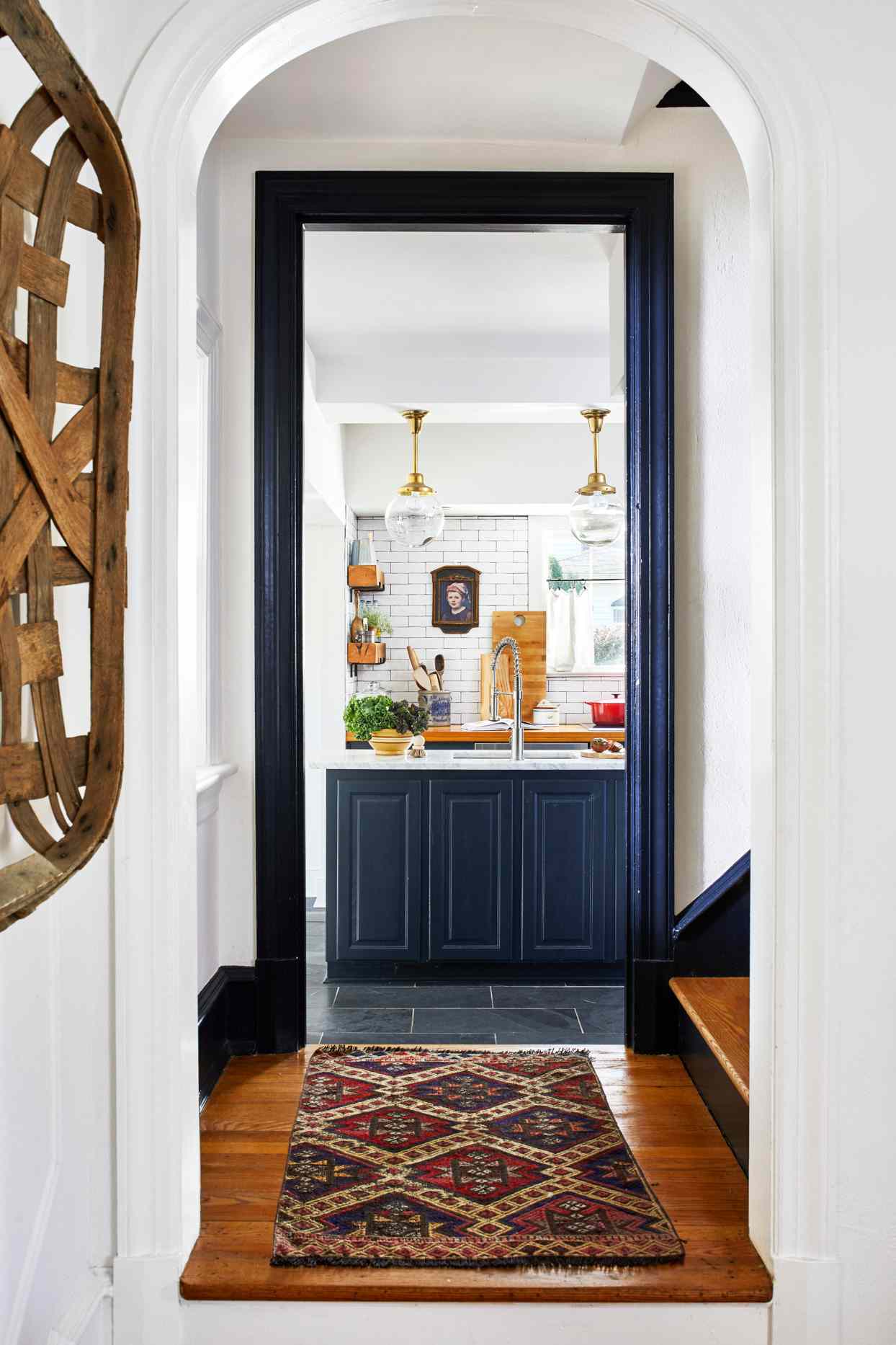 rounded archway into navy and white kitchen