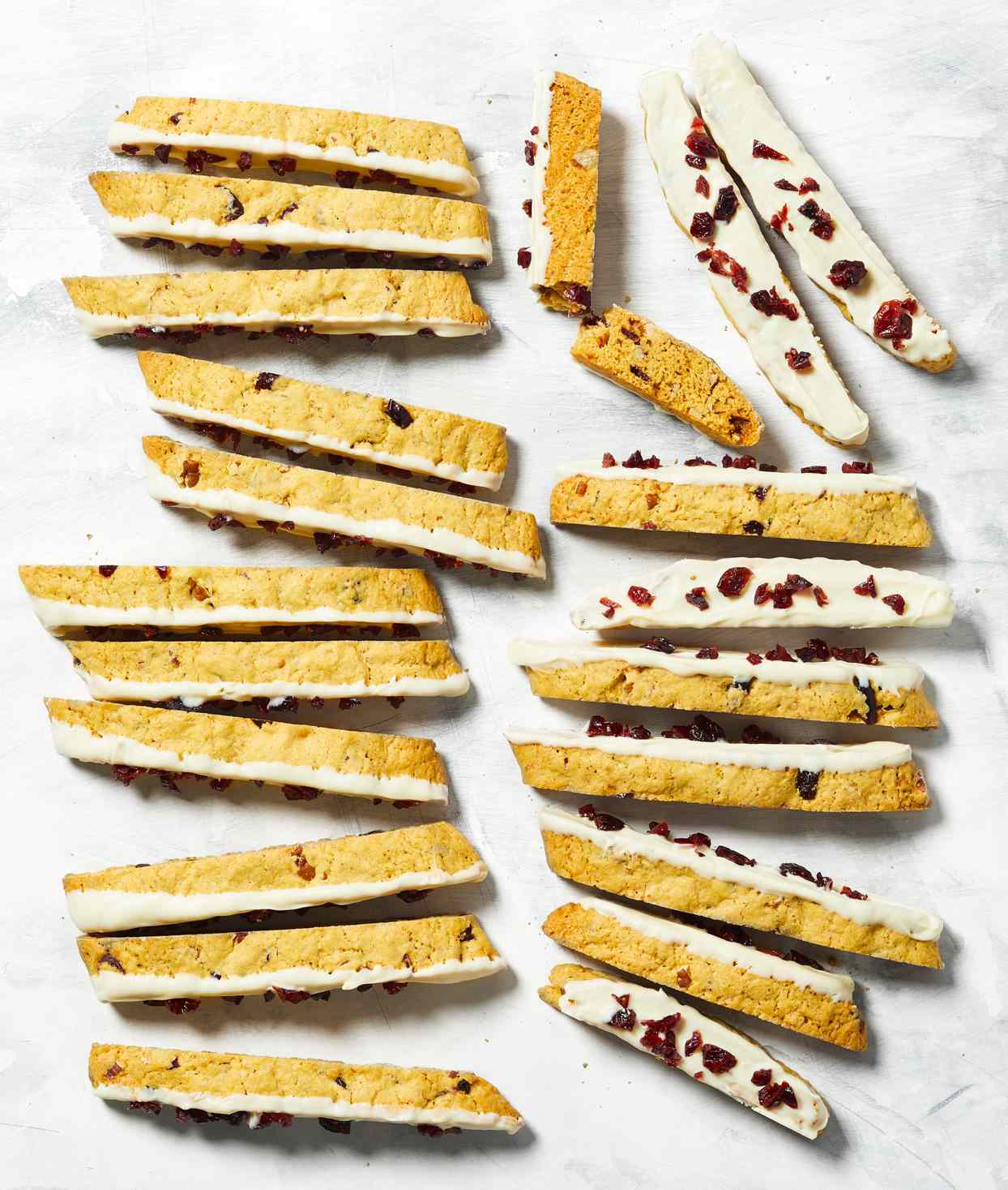 Pumpkin Biscotti topped with icing and cranberries on white background