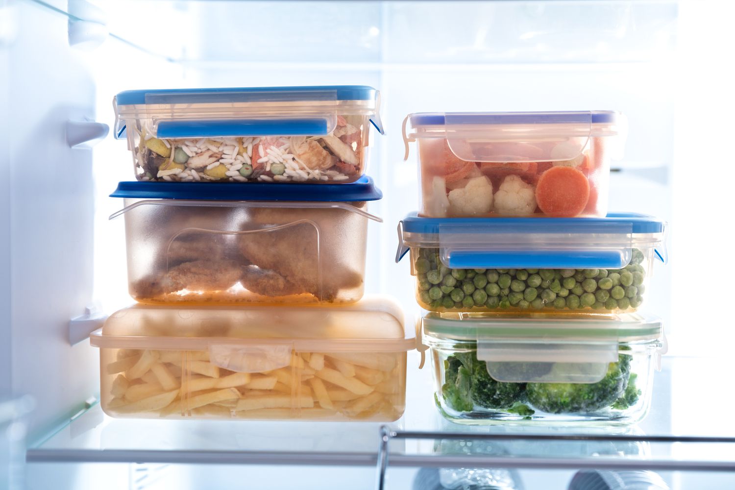 leftover food in plastic containers inside refrigerator