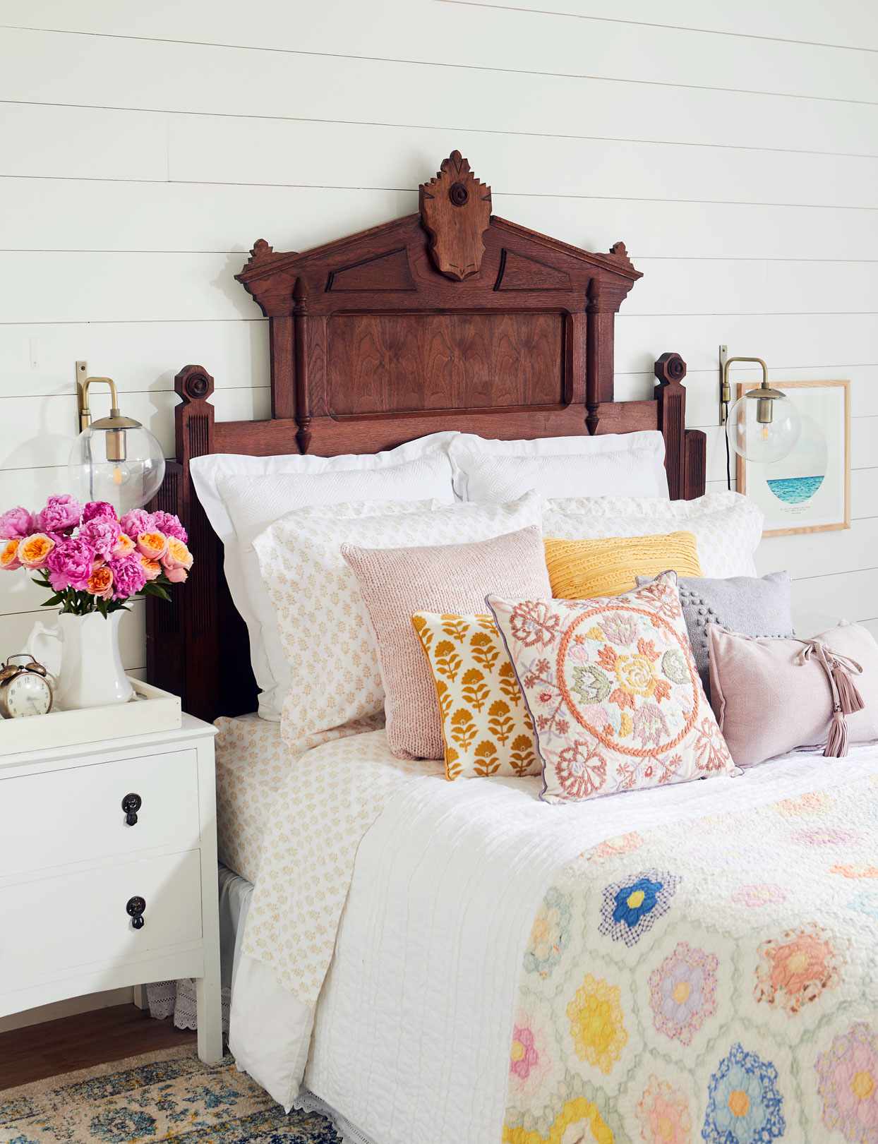 bed with throw pillows and dark wood headboard