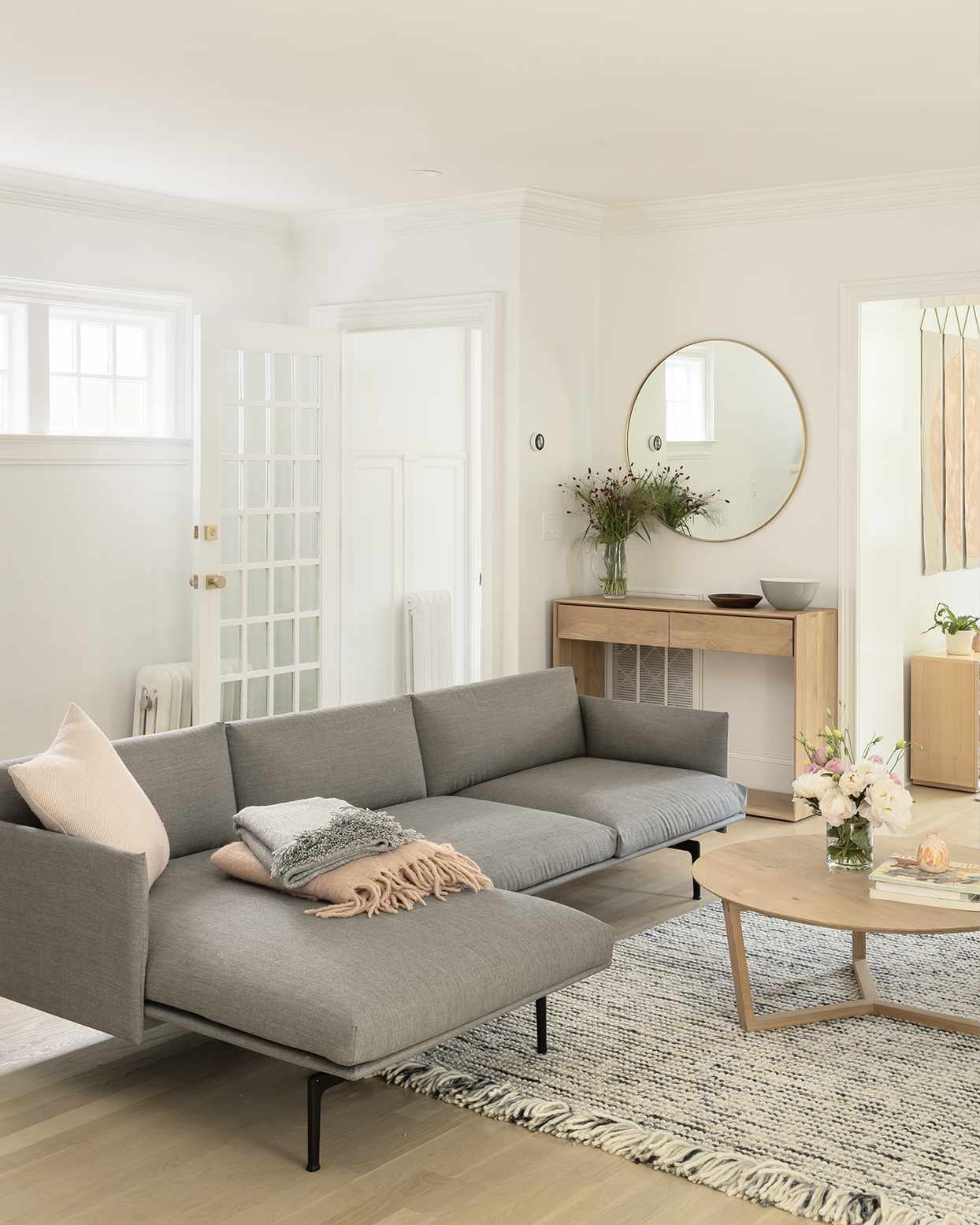 minimalist living room with gray sofa and wood floors