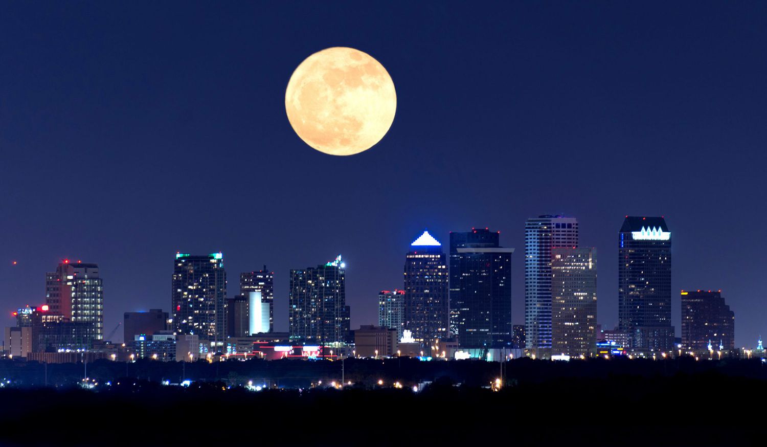 full moon rising over Tampa, Florida skyline at night