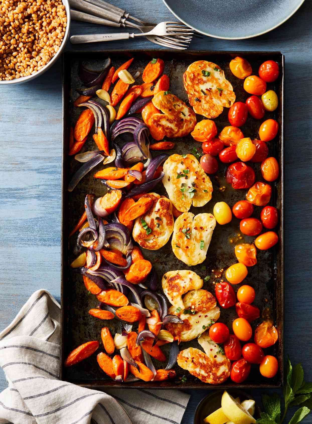 Sheet pan of Roasted Vegetables and Halloumi Cheese and bowl of wheat berries