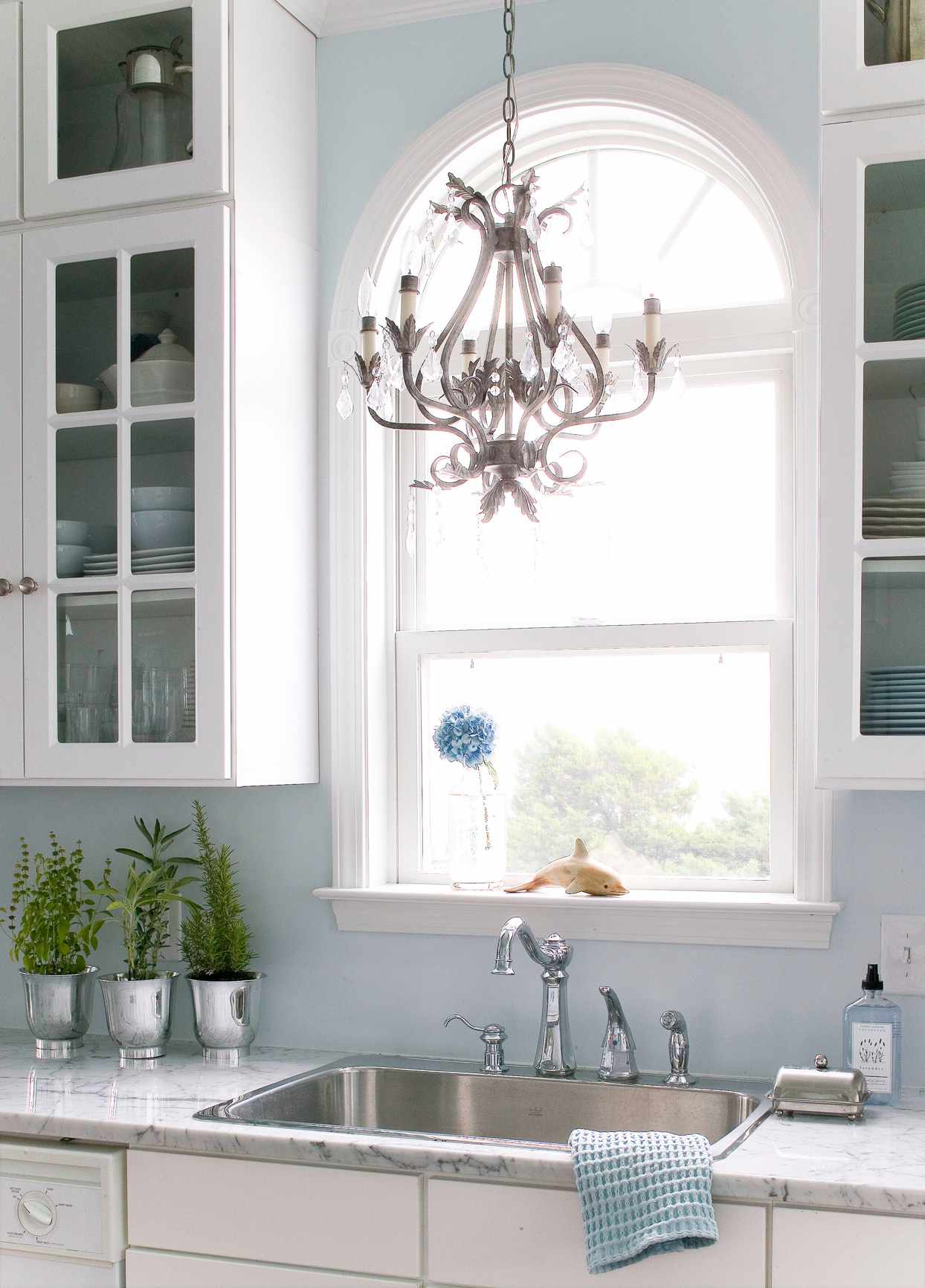 kitchen sink with window and chandelier