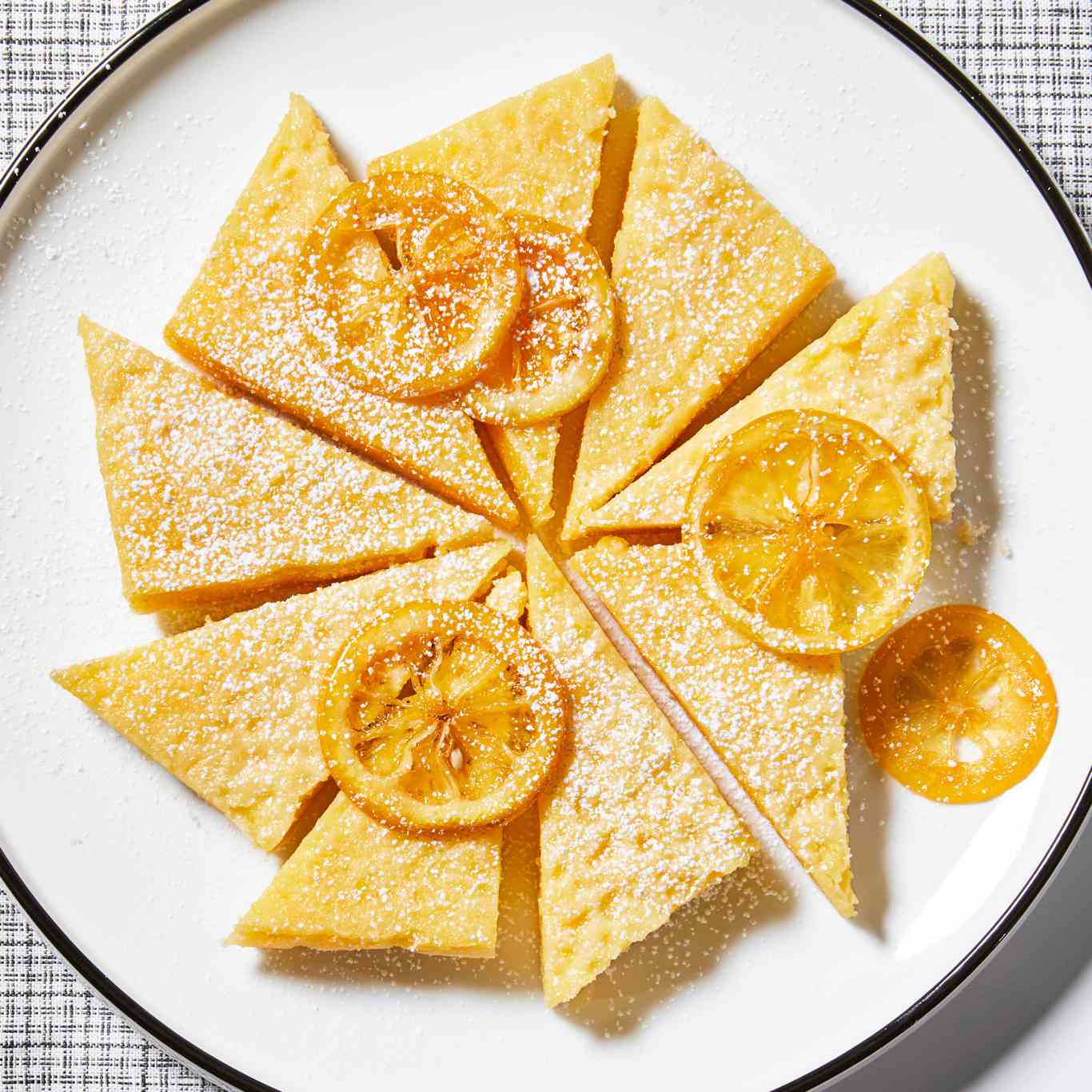 Lemon Chess Pie Bars cut into triangles on white place with lemon slices