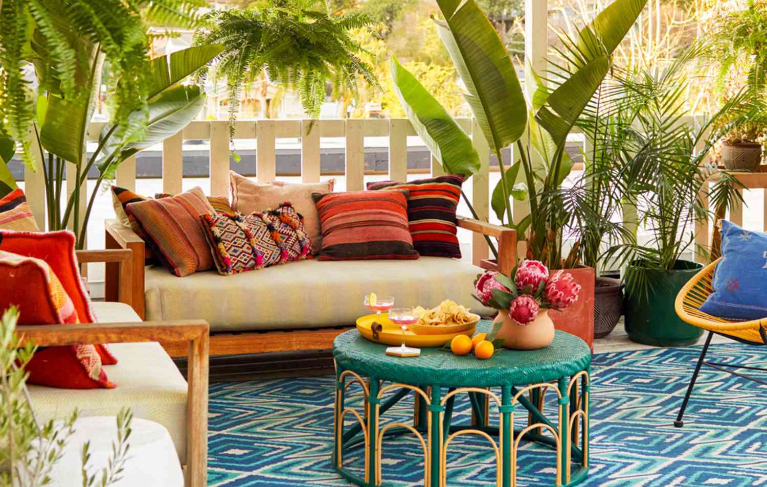 colorful outdoor lounge area with tropical plants and boho decor