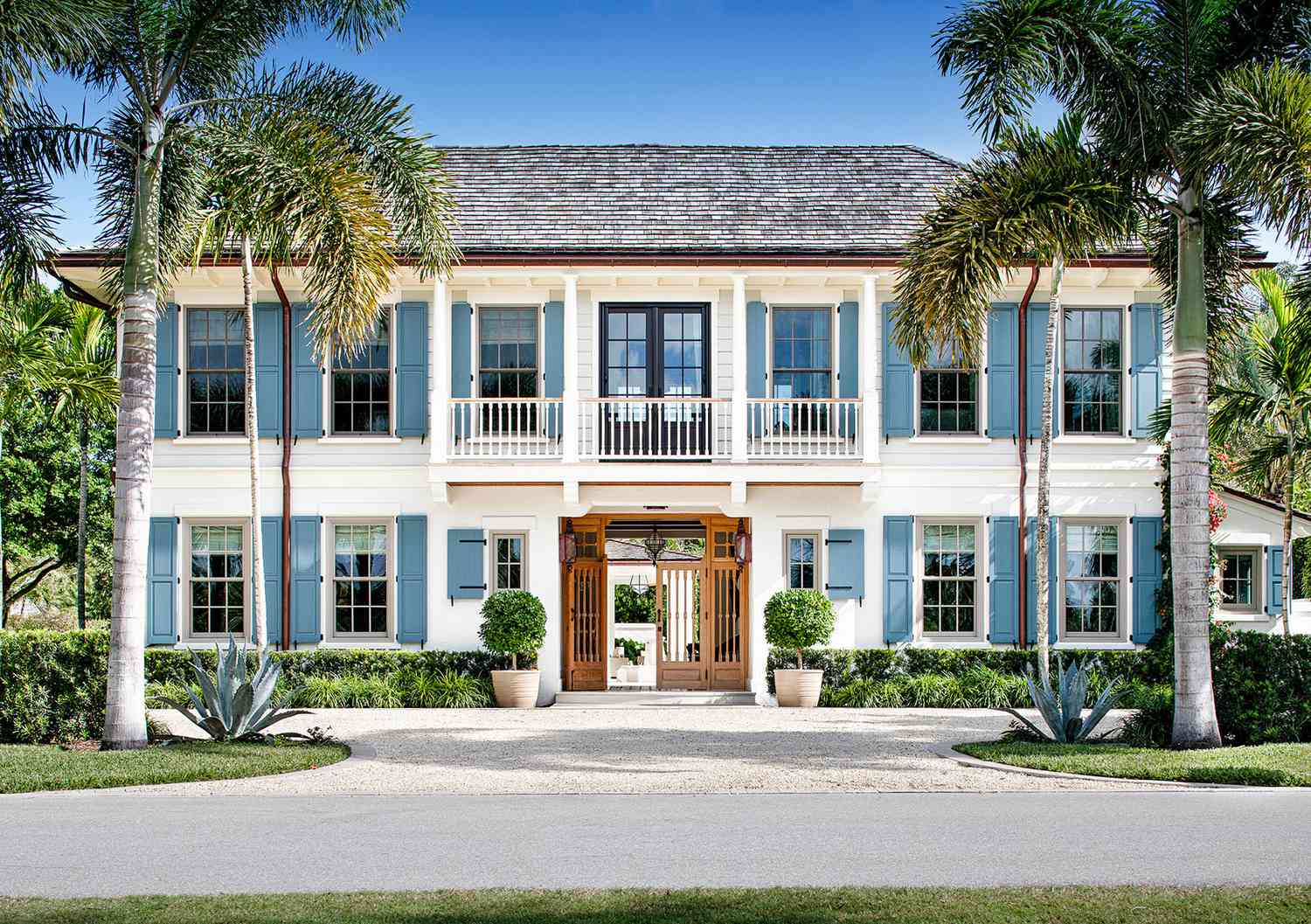 white colonial blue shutters wood french doors palm trees copper gutters topiaries