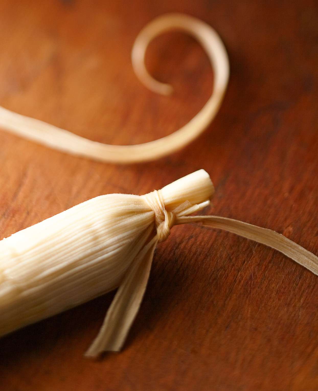 tying the ends of tamales