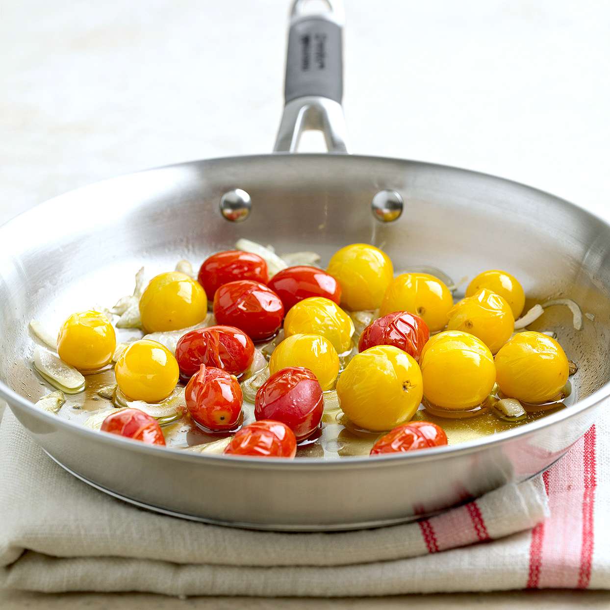 sauteed red yellow cherry tomatoes pan striped red napkin