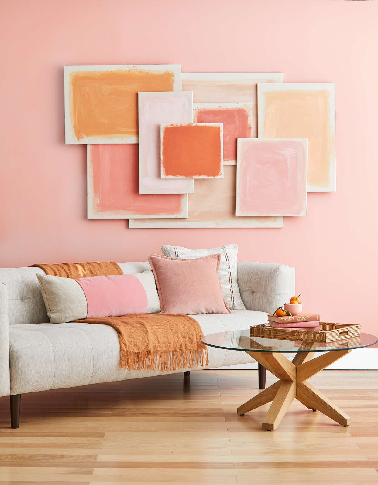 millennial pink wall with sofa, coffee table and pink themed decor and wall hangings