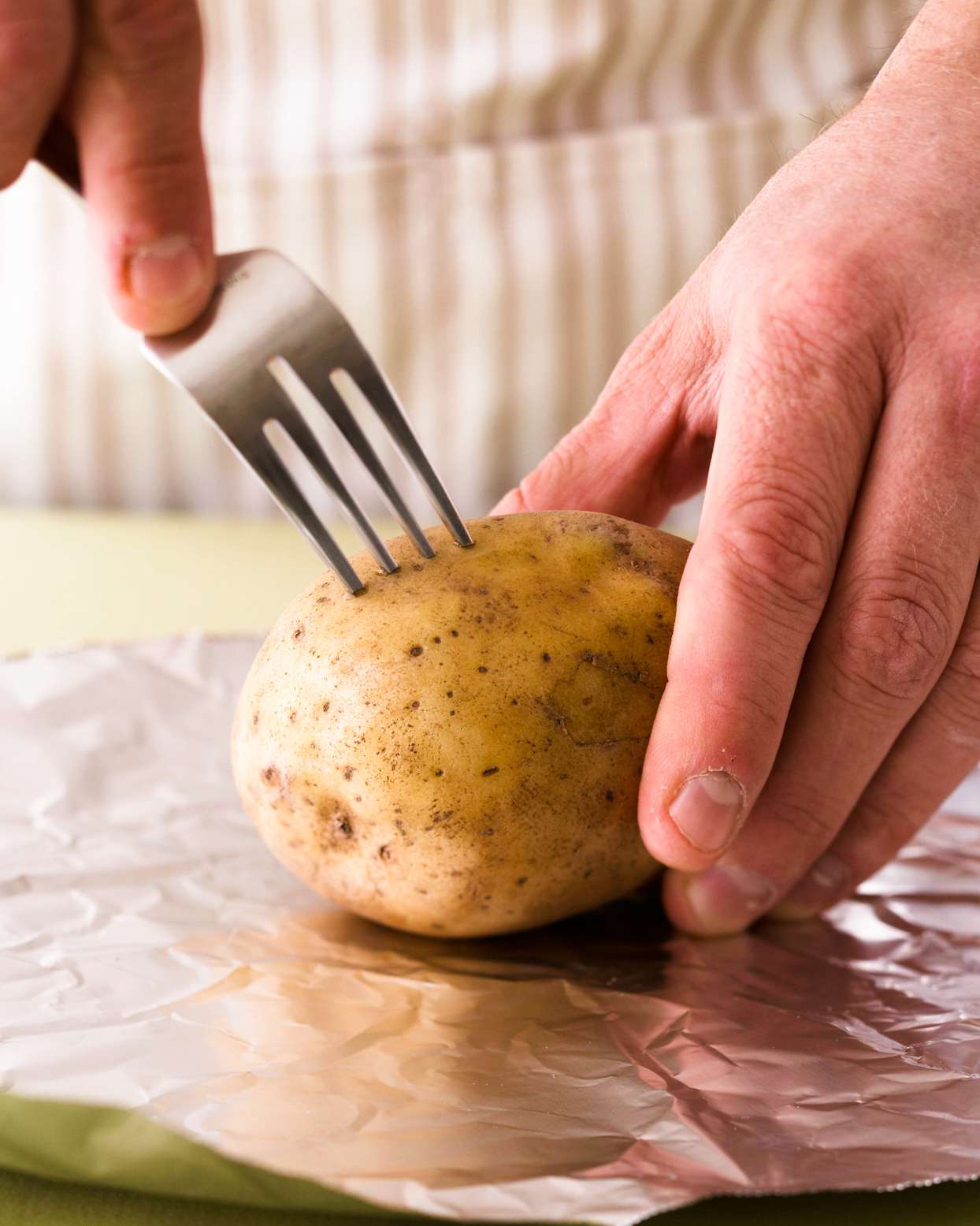pricking potato with fork