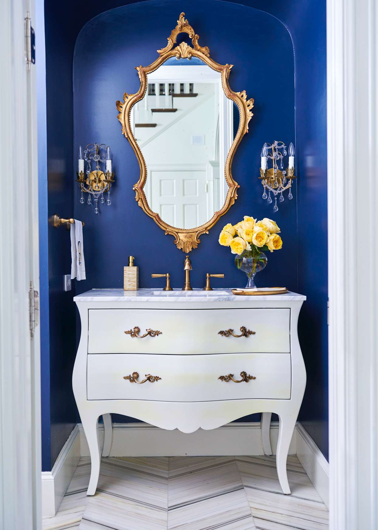 blue bathroom with gold mirror and victorian vanity