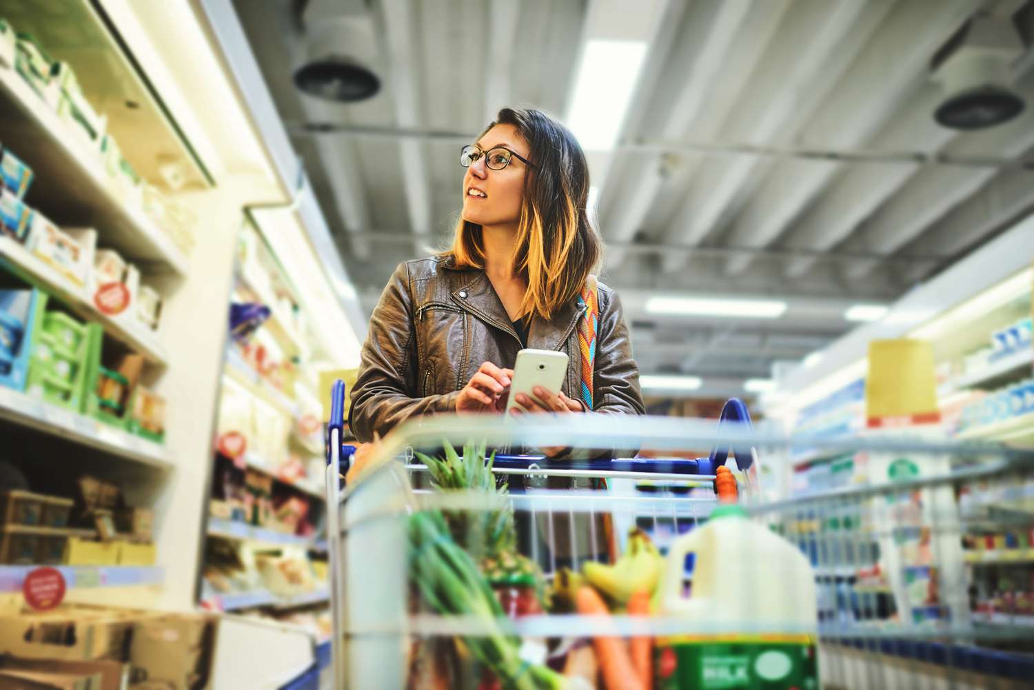 woman shopping for groceries in with shopping cart