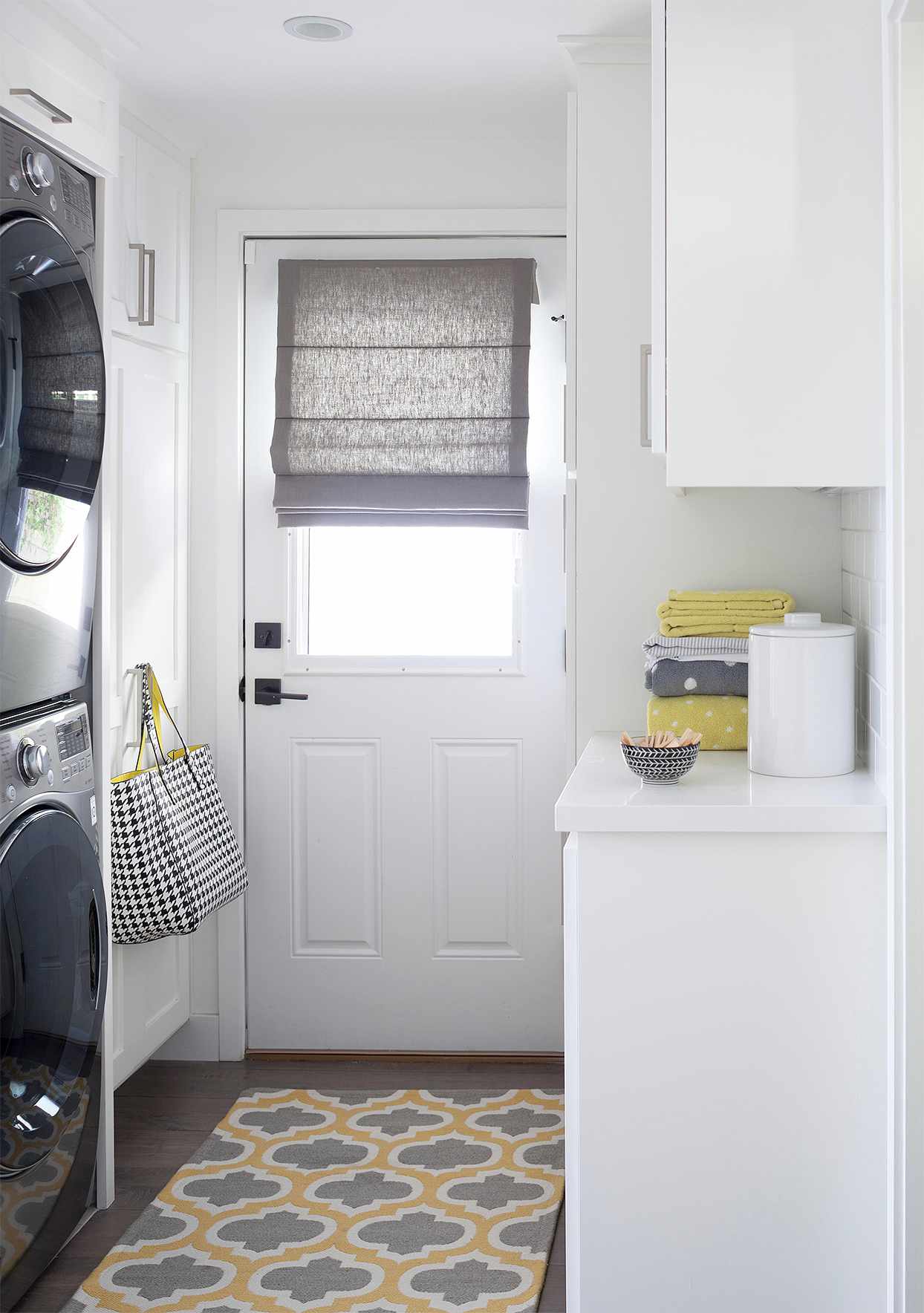 minimalist mudroom white stacked appliances yellow gray accents