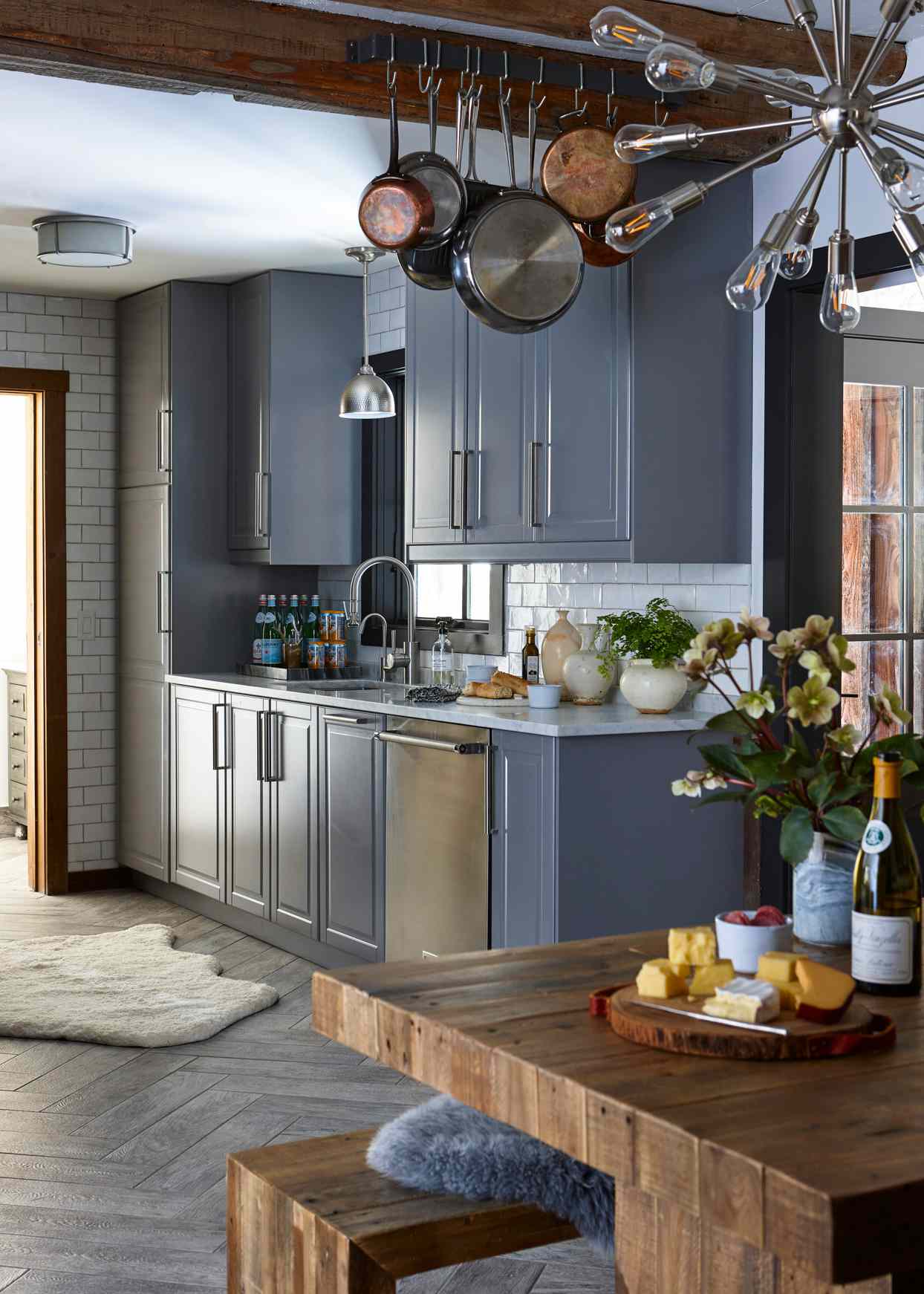 blue kitchen cabinets with dark wood beams