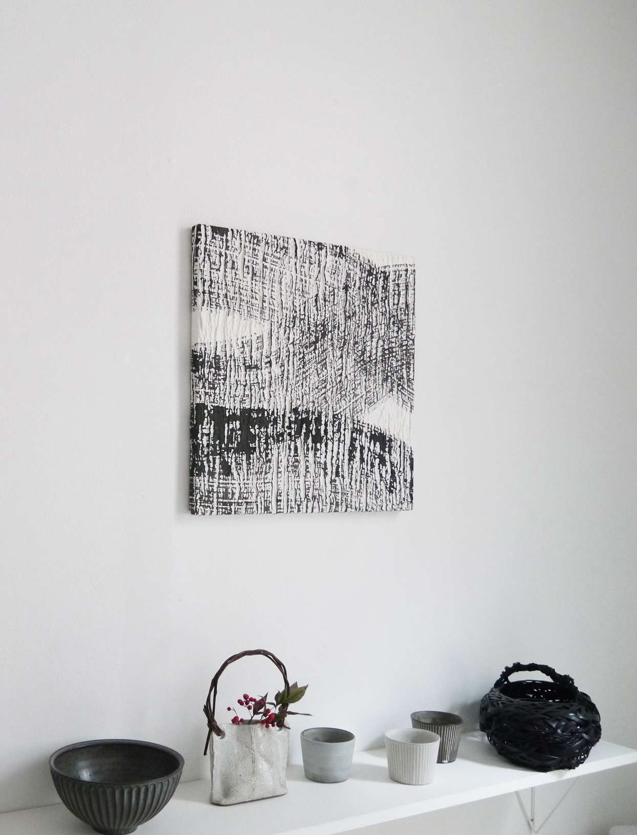 white wall with washi wallpaper and ceramic art objects on shelf