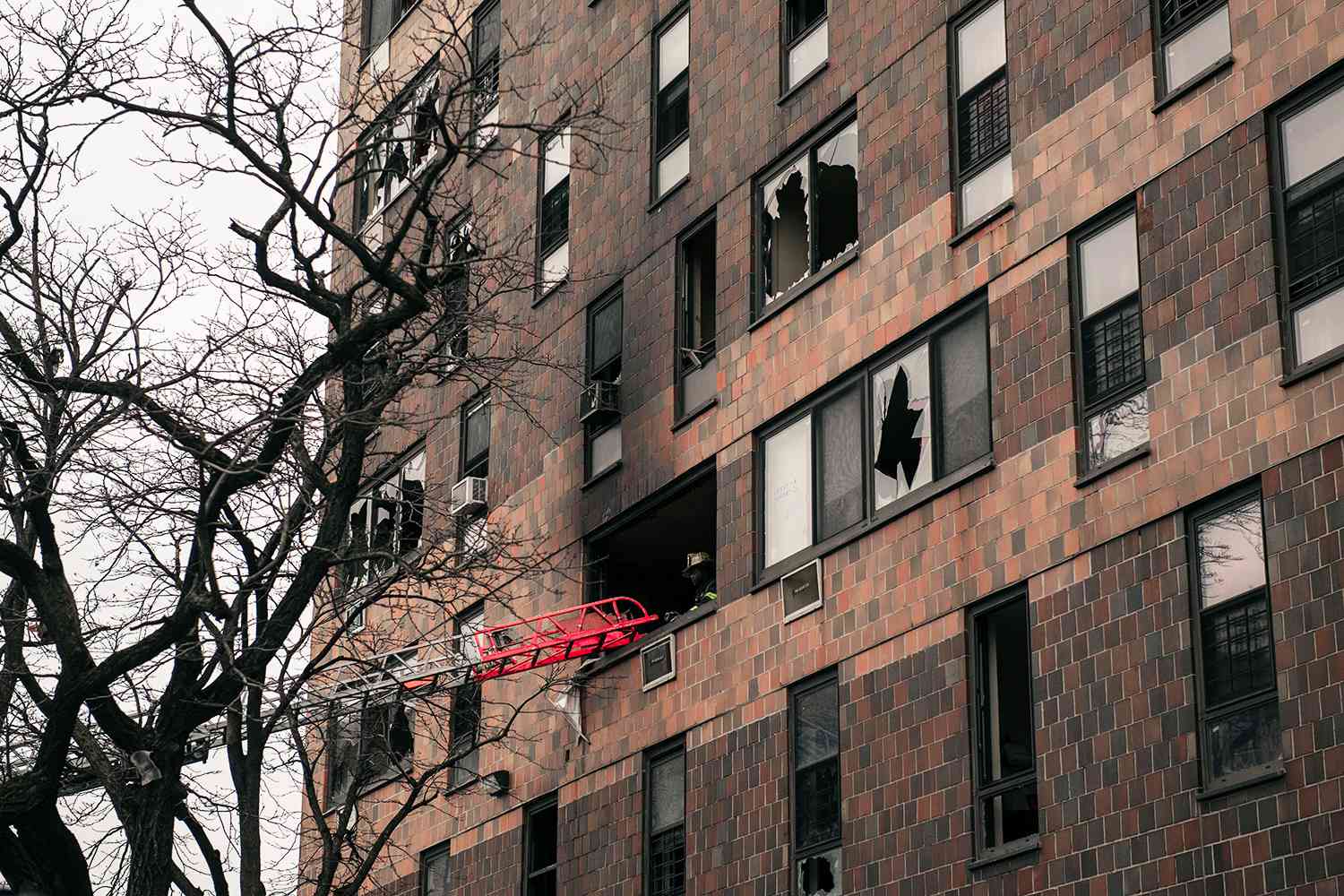 Broken windows and charred bricks mark the exterior of a 19-story residential building after a fire erupted in the morning on January 9, 2022 in the Bronx borough of New York City. Reports indicate over 50 people were injured.