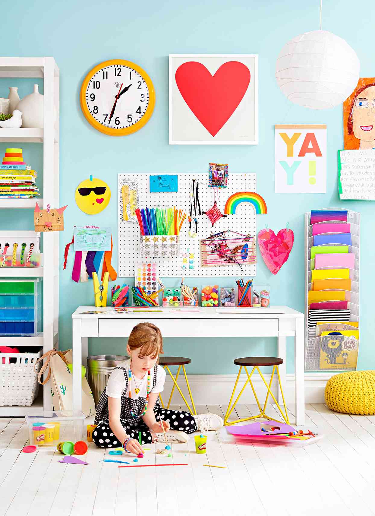 girl playing with play dough in colorful room