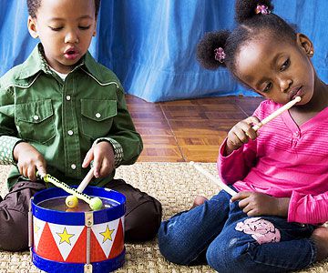 toddlers playing with toy drums