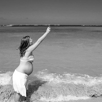 pregnant woman reaching in air