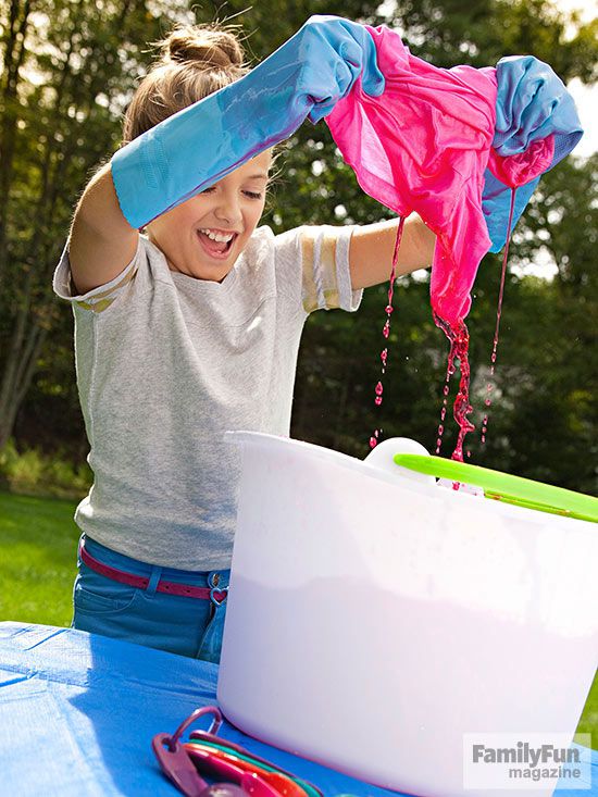 Girl dyeing shirt over white bucket