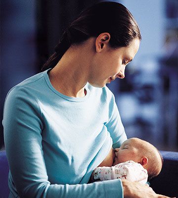 Woman in Blue Shirt Breastfeeding Baby