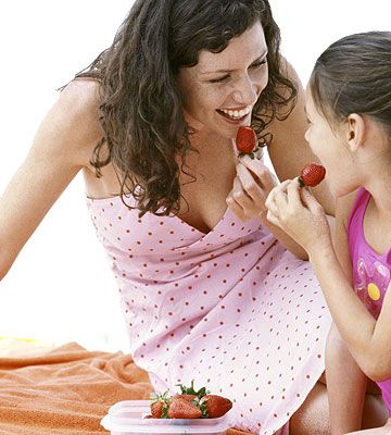 mother and daughter eating strawberries
