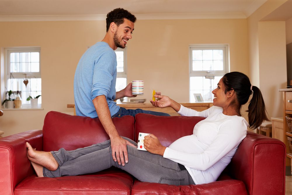 pregnant woman drinking coffee on the couch