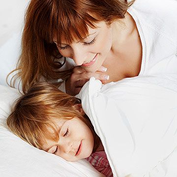 mother putting child to bed