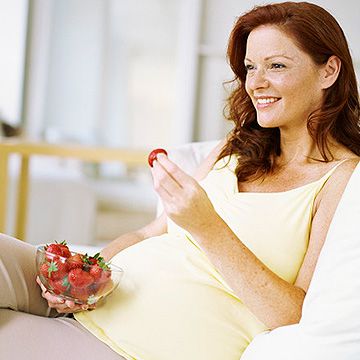 pregnant woman eating strawberries