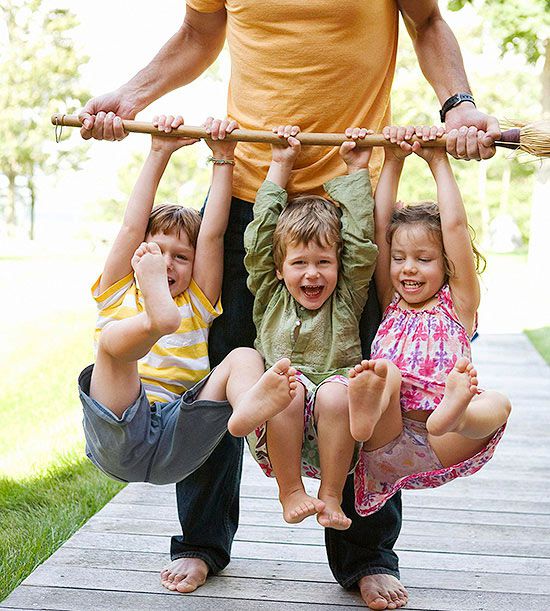 Three kids hanging on dad
