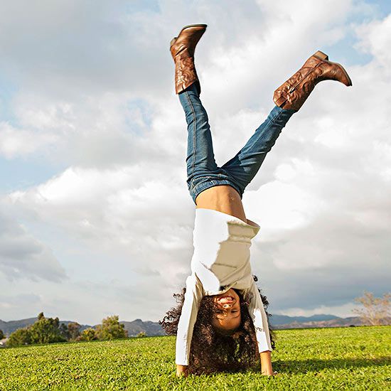 Girl doing cartwheel in a field
