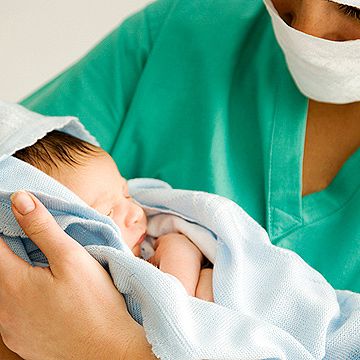 midwife holding newborn