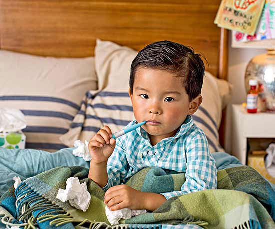Boy in bed with thermometer