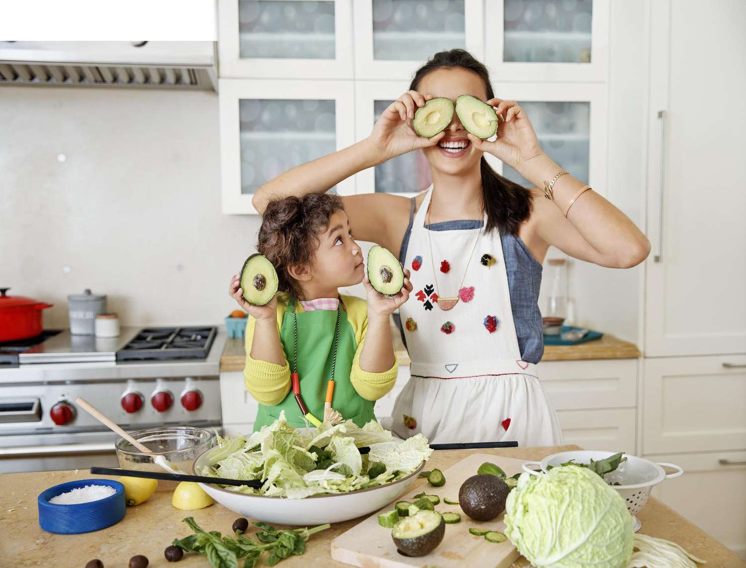 Mother and Daughter Cooking Makes Salad Having Fun Avocado Eyes