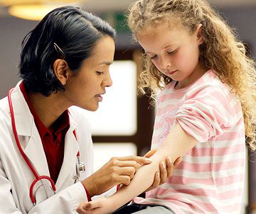 doctor inspecting child's arm