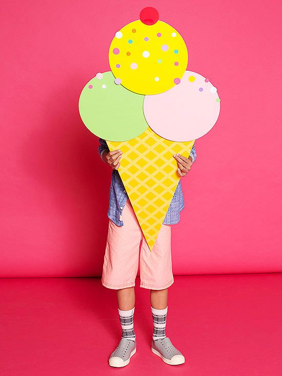 Kid standing behind large paper ice cream cone