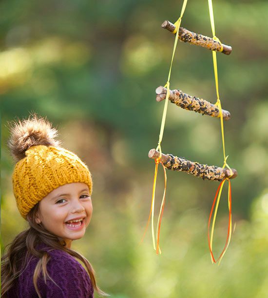 Girl and three-tied stick bird feeder