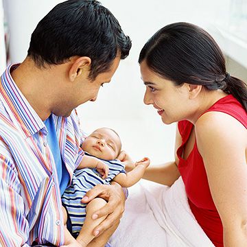 parents looking at their newborn baby