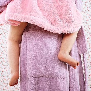 mother holding toddler in bathrobe