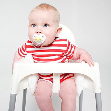 baby in highchair with pacifier